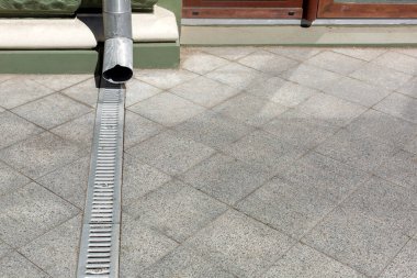 Mühendislik yapısı ön cephe binasına çöktü. Gri taş granit kaldırımların drenaj ızgarası zemindeki kare fayanslardan fotokopi alanına kadar uzandı. Şehir altyapısını kapattık..