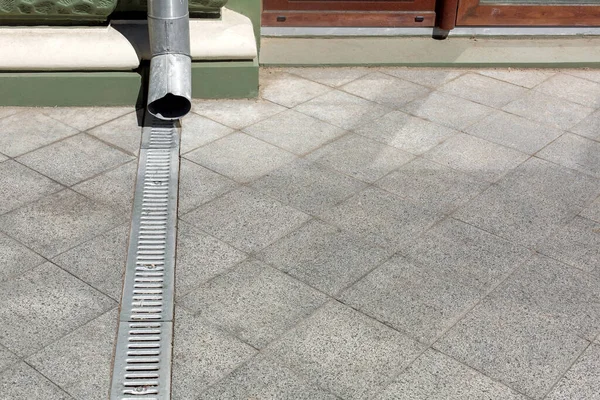 Mühendislik yapısı ön cephe binasına çöktü. Gri taş granit kaldırımların drenaj ızgarası zemindeki kare fayanslardan fotokopi alanına kadar uzandı. Şehir altyapısını kapattık..