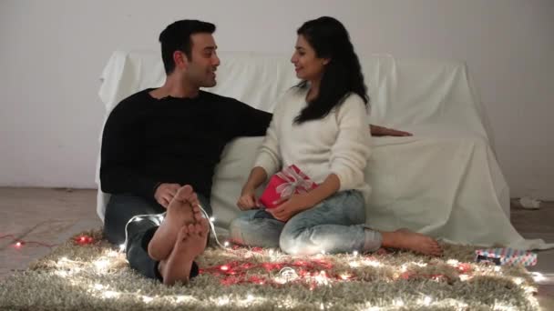 Beau Jeune Couple Heureux Assis Sur Sol Échangeant Des Cadeaux — Video