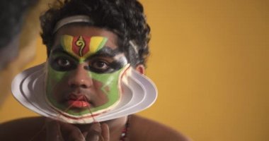 Chuttikaran, Kathakali dansçısının yüzünü boyuyor.