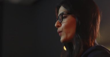 Arkadaşlarıyla sohbet ederken gülümseyen genç bir kadın.