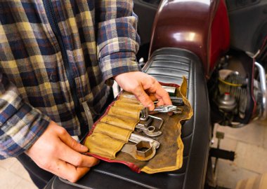 Motosiklet koltuğunda alet seti olan adam