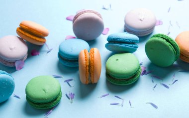 Mavi bir arka plan üzerinde renkli lezzetli kurabiyeler