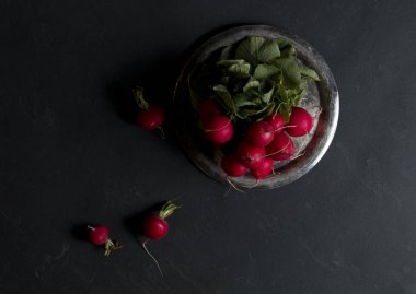 Karanlık bir arka plan üzerinde taze turp.