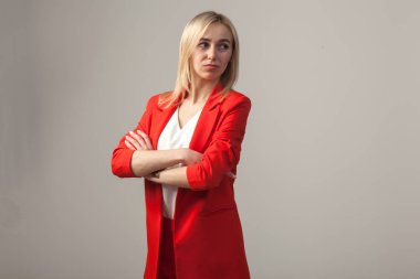 Bir ceket ve beyaz bluz ayakta beyaz izole arka planda bir poz ile kırmızı sıkı elbiseli Genç güzel beyaz sarışın kız