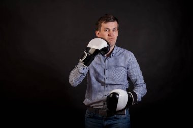 Esmer adam boks eldivenli ellerinde ekose gömlekli kendini izole siyah arka plan üzerine atıyor