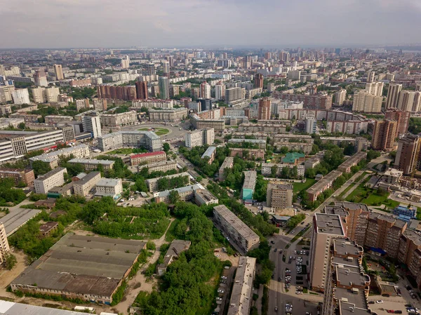 Old and new russian buildings in green area in the city with a lot of cars. Russian streets, Novosibirsk.