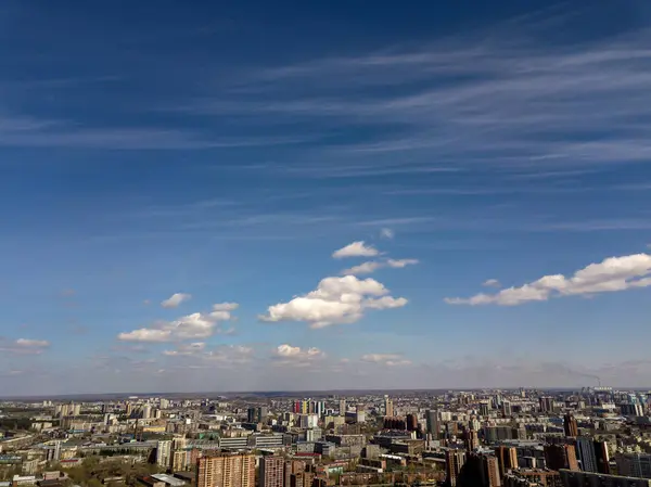Clouds in the blue sky wih buildings under them at Novosibirsk, Russia. Streets and skyline.