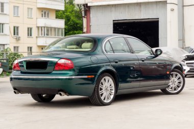 Novosibirsk, Rusya Federasyonu - 06.28.2018: Parlak yeşil Jaguar S-type 2007 arka görüntülemek bir park yeri diğer arabalar arasında iyi durumda hafif bej iç