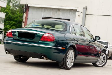 Novosibirsk, Rusya Federasyonu - 06.28.2018: Parlak yeşil Jaguar S-type 2007 arka görüntülemek bir park yeri diğer arabalar arasında iyi durumda hafif bej iç