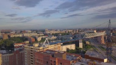 Yapım aşamasında bir mavi kule vinç, vinç, sonunda kırmızı fener ile yeni bir modern ev hava görünümünü İnşaat malzemeleri en üst kat, tuğla, çimento, mavi bir gökyüzü ve bulutlar karşı