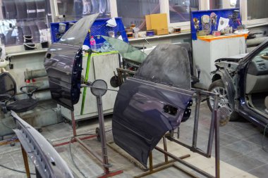 İki araba mavi kapı parçaları araba tamircisi ve araçları bir kazadan sonra vücut parçaları tamiri için odada resimde sonra rafları yüklenir