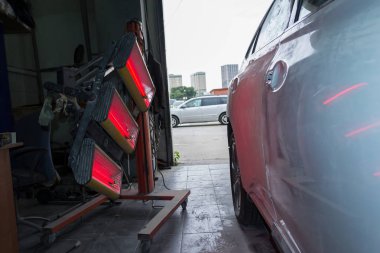 Kızılötesi beyaz araba vücut parçaları üzerinde vücut tamircisi beyaz suv araca özel araç ve ekipmanlar kullanarak çalışma ortamı kırmızı fener ile macun ve boya uygulandıktan sonra kurutma