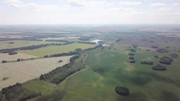 Vue aérienne tournant à 360 degrés au-dessus de la route au milieu d'un grand nombre de champs colorés plantés de plantes pour l'agriculture par une journée d'automne ensoleillée avec un ciel bleu et des nuages 