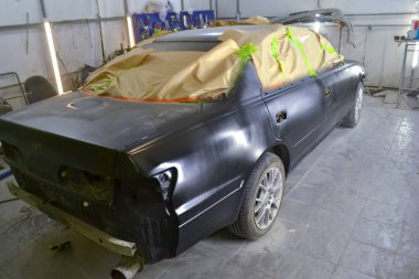 Kağıt beyaz duvarları ve arka ışık ile vücut onarım için özel bir atölyede boya girmesini windows ile vücut kaplı boyama sonra Sedan vücuttaki siyah araba