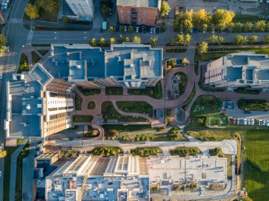 Orada olan birçok yürüyüş parça araba olmadan ve yeşil çimenler dışında olduğu araba park yerinde ot avluda şehirde yeni binaların havadan görünümü
