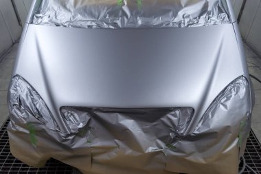 Gümüş bir arabanın arka koltuğunda olan bazı kısımları boya damlacıkları özel kutusunda ve ekipman ile bir araba vücut tamir dükkanında sıçramalarına kağıttan tarafından korunmaktadır bir hatchback tam resmini