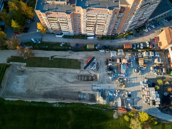 Bir bina inşaat havadan görünümü site İnşaat malzemeleri için moloz taşı ve tuğla çimento, sonbahar bir güneşli gün batımında yeşil çim çimen ile çevrili bir yerde