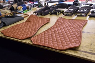 Araba ile kahverengi renk araçları ile bir iç tasarım atölyesinde bir aracın ön yolcu için hakiki deri dikiş iplik elmas şeklindeki 3d el yapımı kilim