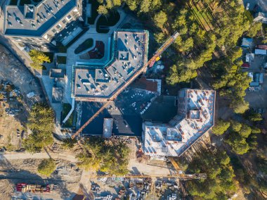 Nehir kıyısında olumlu bir ortam, bir sürü ekipman maliyeti yakınlarında bir yeşil iğne yapraklı orman ortasında üç elit konut bina inşaat havadan görünümü