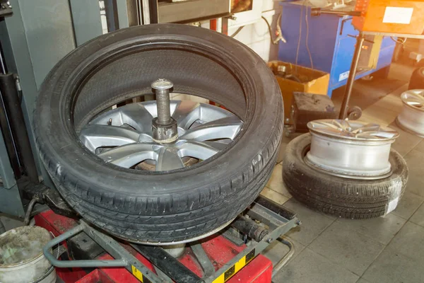 Car wheel half taken from the disk to perform tire mounting and fitting on a special machine in the workshop for repairing vehicles before the start of the winter season