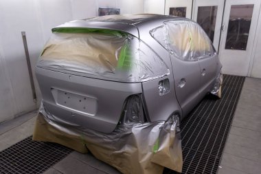 Gümüş bir arabanın arka koltuğunda olan bazı kısımları boya damlacıkları özel kutusunda ve ekipman ile bir araba vücut tamir dükkanında sıçramalarına kağıttan tarafından korunmaktadır bir hatchback tam resmini