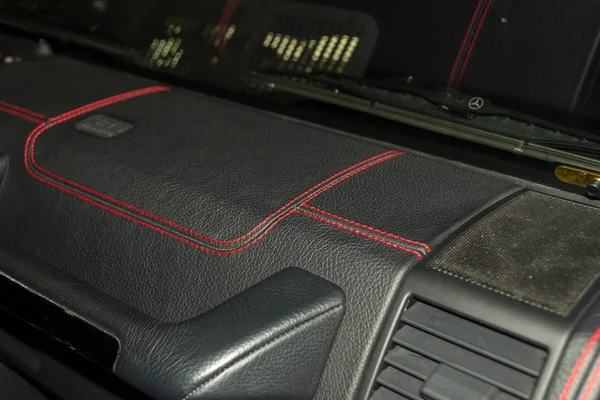 車両のインテリア デザインのワーク ショップのコントラストステッチと赤い色のステッチ ダブル スレッド ブラック カラーの革からの車のパネルの内部のパーツの表示 — ストック写真