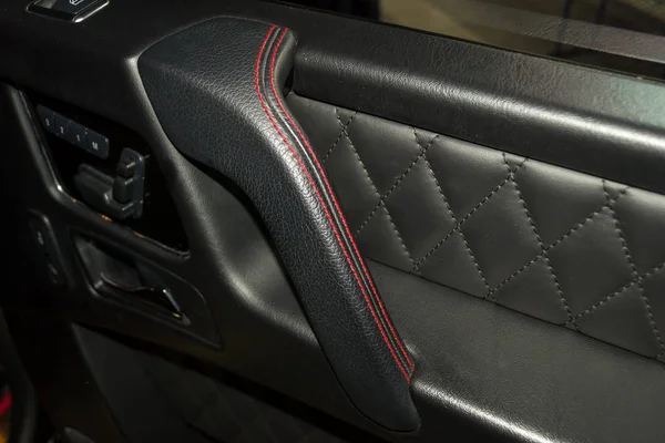車両のインテリア デザインのワーク ショップのコントラストステッチと赤い色のステッチ ダブル スレッド ブラック カラーの革から車のドアの内部のパーツの表示 — ストック写真