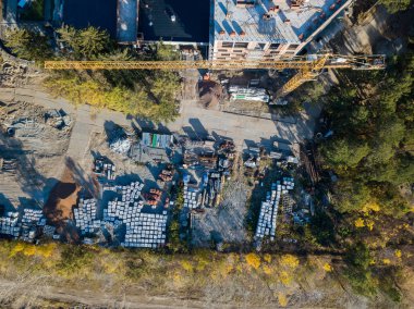 Bir bina inşaat havadan görünümü site İnşaat malzemeleri için moloz taşı ve tuğla çimento, sonbahar bir güneşli gün batımında yeşil çim çimen ile çevrili bir yerde