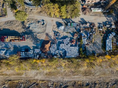 Bir bina inşaat havadan görünümü site İnşaat malzemeleri için moloz taşı ve tuğla çimento, sonbahar bir güneşli gün batımında yeşil çim çimen ile çevrili bir yerde