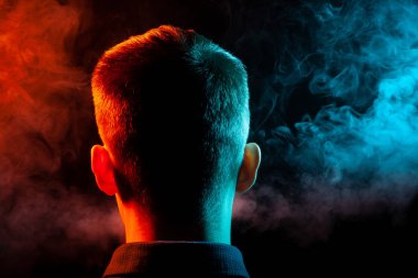 Bir vape sigara ve çok renkli duman yeşil ve kırmızı farklı yönden kendini izole bir siyah arka plan üzerine adlı parçasıyla birlikte kullanılmalıdır gömlekli bir adam kafasına arkadan görünüm