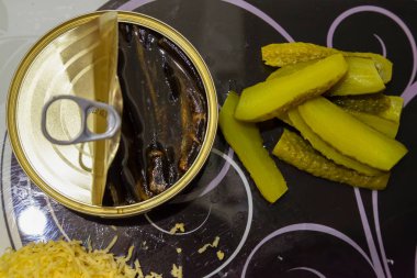 Bir düz siyah ve beyaz cam kesme tahtası üstten görünüm açık bir teneke yağ, kıyılmış tuzlu yeşil salatalık ve rendelenmiş peynir sürüsünü ile yatıyordu