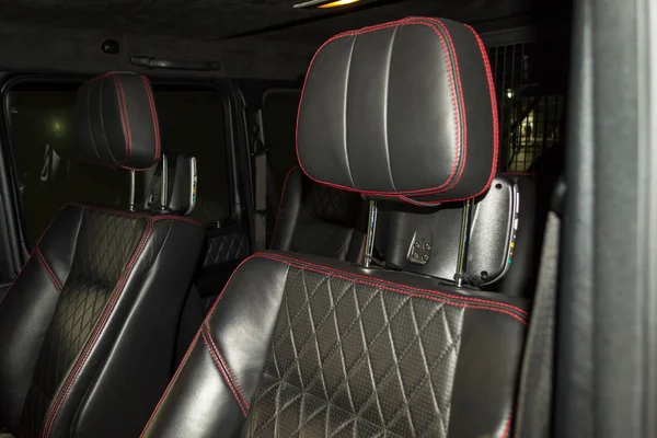 从黑色皮革的汽车座椅内饰的一部分 在汽车内饰设计车间的对比缝线缝制的红色双线的视图 — 图库照片