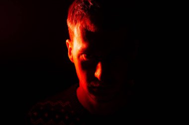 Kimin yarım baş gölge içinde gizli bir beyaz adam ve yarım kırmızı ve turuncu vurgulanır ikinci bir portre. Kötü ruh hali.