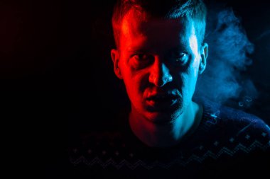 Kızgın ve kötü duygular bir yüz mash ve duman etrafında siyah bir izole arka plan üzerinde yok bir adam portresi. Gölge rengi kırmızı ve mavi aydınlatma ile adam yüzü.