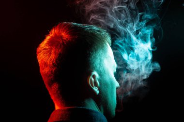 Bir vape sigara ve exhaling gömlekli çocuklar kafasının arkasına bir görünüm çok renkli duman yeşilden farklı iki taraf için de kendini bir siyah arka plan izole