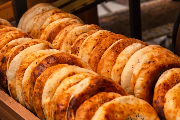 Close-up of tandyr bread cakes freshly baked appetizingly laid out in even rows on the counter of a shopping center in the bakery section. Natural products in the store.
