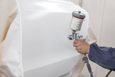 Bir kutu içinde iş sabitleme, bir araba tamircisi elinde bir araç bir kazadan sonra teknolojisiyle daha fazla taşıma vücut için hazırlanmış beyaz kapı üzerine boya püskürtme tutuyor..