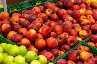 Güzel, Olgun, taze meyve bir süpermarkette: yeşil, sarı, kırmızı elma, bir geniş ürün yelpazesine sahip, çeşitli seçenekleri satırları yerleştirilir.