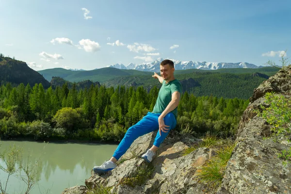 Hombre Sienta Una Montaña Una Piedra Una Camiseta Verde Pantalones — Foto de Stock