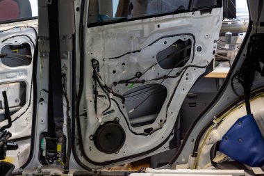 Araba vücut beyaz crossover servis istasyonunda, kabin restorasyonu tamiri. Yan kapı trim panel kaldırıldı, ses sistemi kablolama değiştirildi.