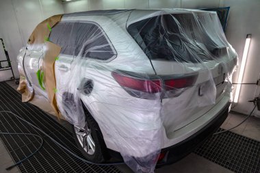 Beyaz araba Suv için vücut onarım atölye boyama. Araba kağıt ile kaplı ve boya isabet örtmek.