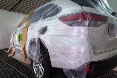 Beyaz araba Suv için vücut onarım atölye boyama. Araba kağıt ile kaplı ve boya isabet örtmek.