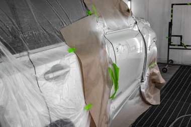 Beyaz araba Suv için vücut onarım atölye boyama. Araba kağıt ile kaplı ve boya isabet örtmek.