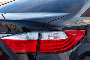 Vücut yakın çekim ve siyah bir araba kırmızı-beyaz farlar tasarımını yıkama ve bagajı yansıtan ışık parlatma sonra temiz ve parlak.