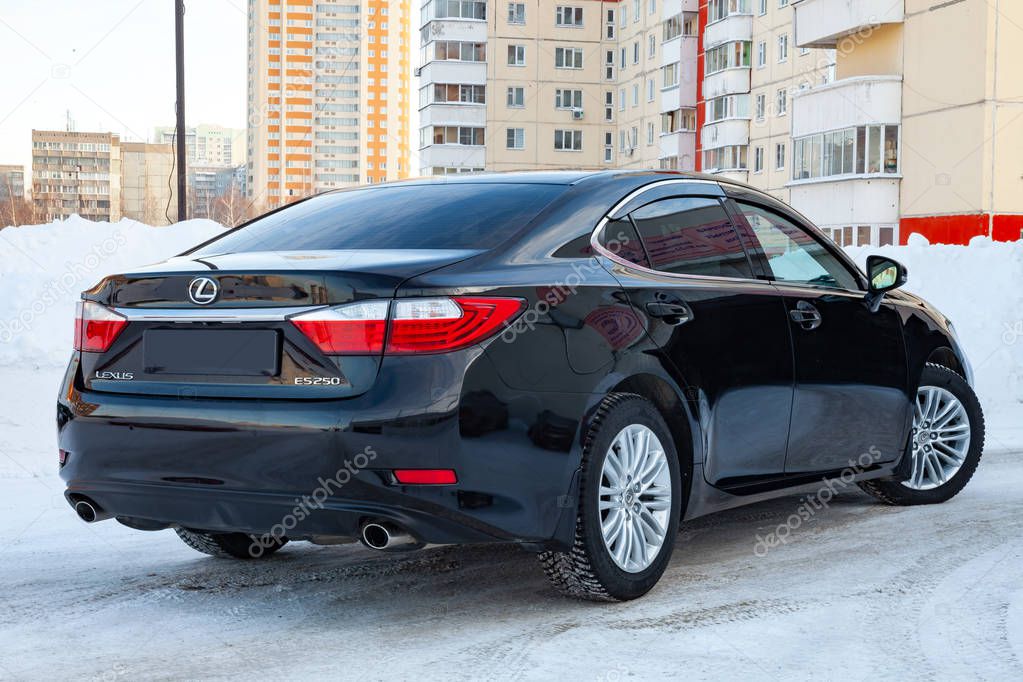 Novosibirsk, Russia - 12.06.2018: Luxury car Japanese premium sedan black Lexus es 250 is exposed on the street in the snow in the parking lot of a car dealership on a city background exposed for sale.