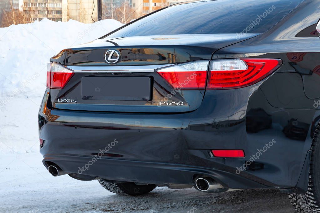 Novosibirsk, Russia - 12.06.2018: Close-up of the back of the car body Lexus es black sedan with the symbols of the Japanese manufacturer on the trunk in the street parking in the snow.