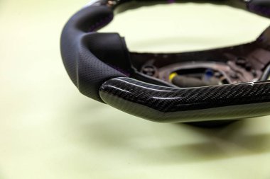 Yedek parçalar ve donatım ayarlama hizmet merkezi Meclisi siyah karbon fiber ve delikli deri yapılmış bir aracın direksiyon simidi parçası kapat.