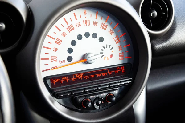 在黑色车载计算机速度计的仪表板上带有显示特写镜头的传感器 在白色背景上带有红色箭头和橙色数字和符号 用于测量车辆速度 — 图库照片