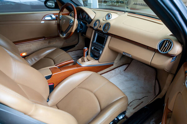 Novosibirsk, Russia - 08.01.2018: The interior of an expensive sportcar coupe Porsche Boxster S 2006 inside the front seats of genuine perforated leather the central control panel with wood and chrome